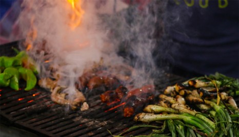 Vegetables and meat on a charcoal grill in the market